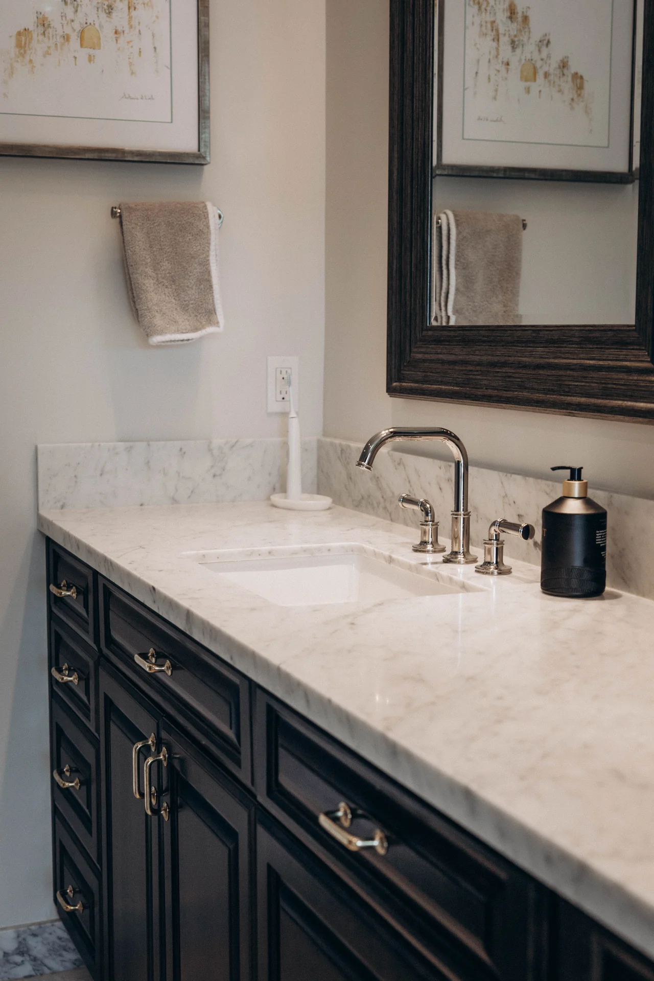 Dark paneled cabinetry, a marble countertop, and polished chrome fittings.